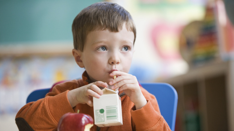 child drinking school milk carton