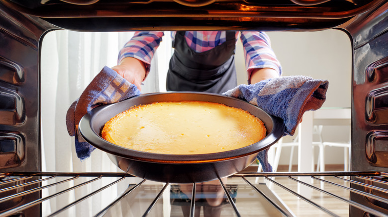 Person taking cake out of oven