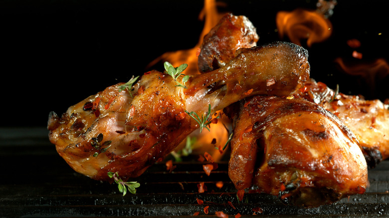 Grilling chicken over a flame