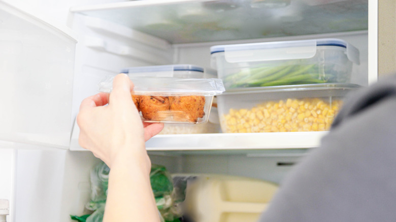 Person putting food in fridge