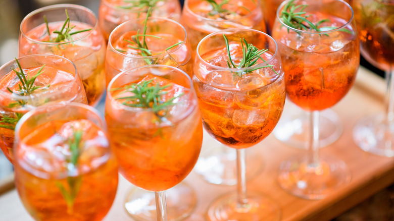 a tray of chilled spritz cocktails with rosemary garnish