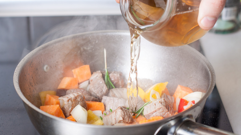 Adding broth to beef stew