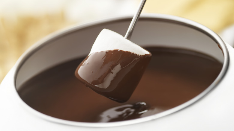 Dipping a marshmallow in chocolate