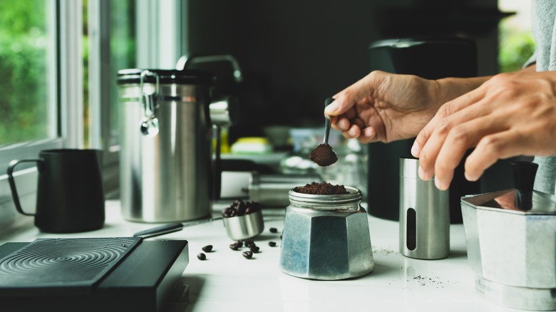 Coffee enthusiast filling moka pot