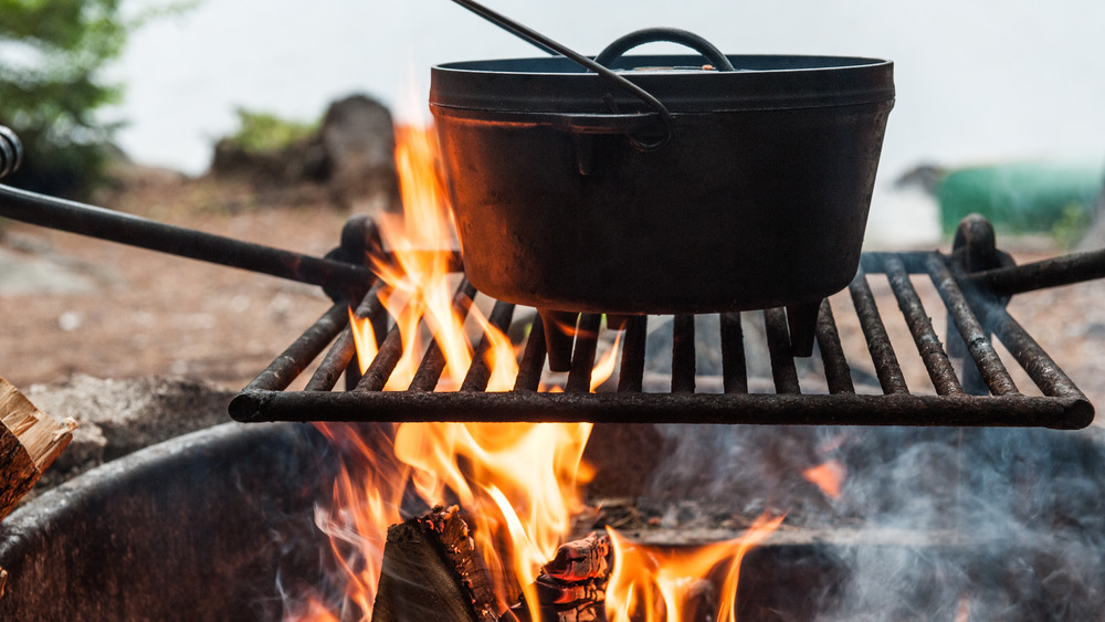 Black cast iron Dutch oven over an open campfire