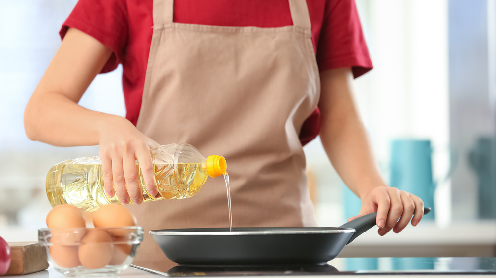 pouring oil on pan for fried eggs