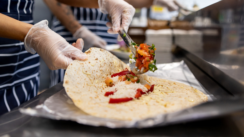 adding ingredients to burrito