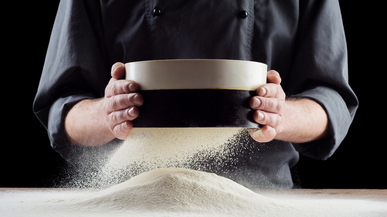 A chef sifting flour