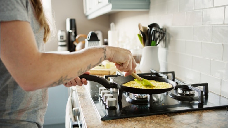 Person scrambling eggs in a pan