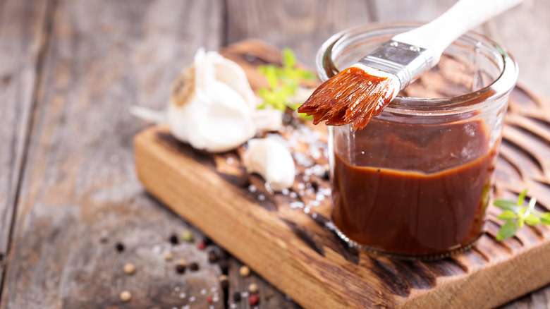 bbq sauce in glass jar with brush