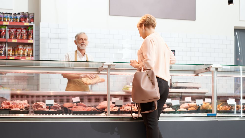 Butcher serving customer