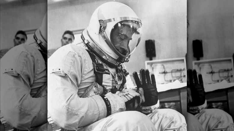 John Young inspecting space suit