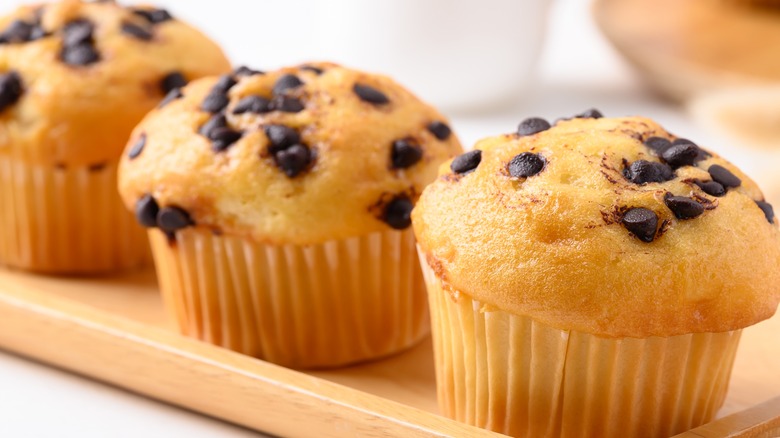 Three small chocolate chip muffins on a tray