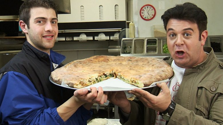 richman and companion holding pizza