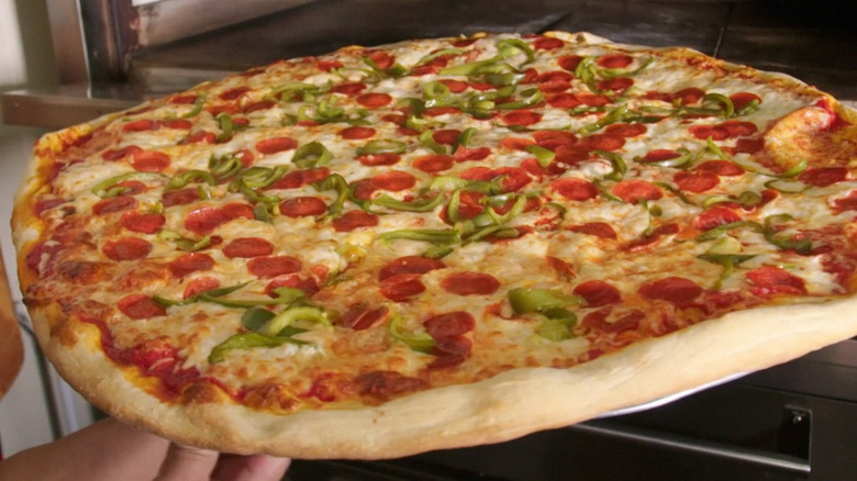 giant pizza exiting oven