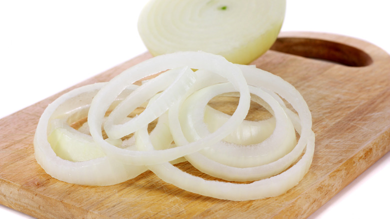 Sliced white onions on board