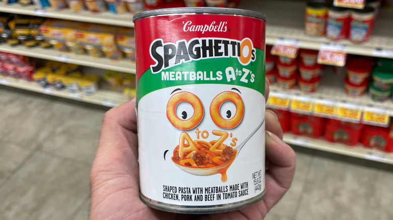 Hand holding a can of SpaghettiOs with meatballs