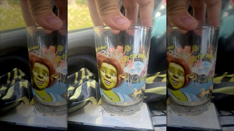 Hand holding glass with Fiona from 'Shrek' on it