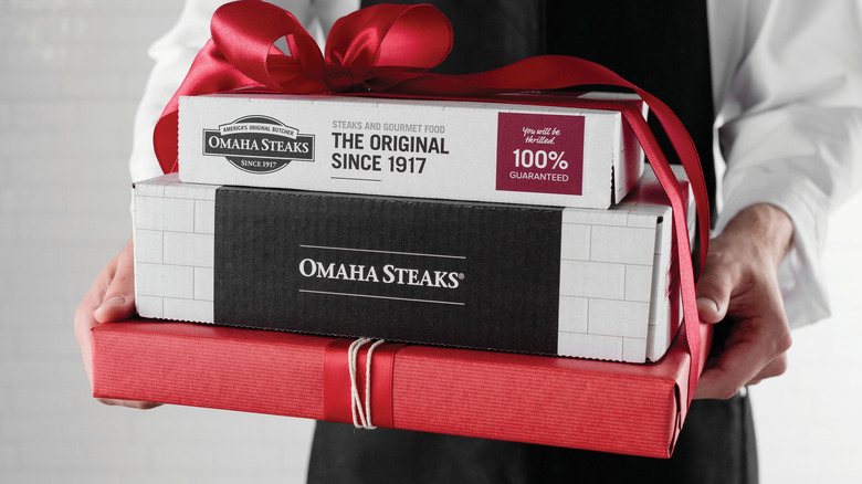 person holding Omaha Steaks products