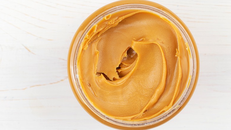 Overhead view of open peanut butter jar