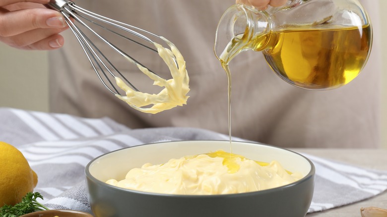 Pouring oil into homemade mayonnaise