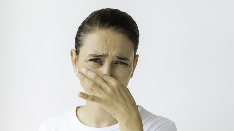 woman smelling something bad