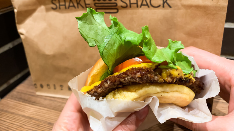 person holding Shake Shack burger