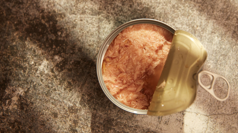 An aerial view of a can of tuna with a partially-opened lid