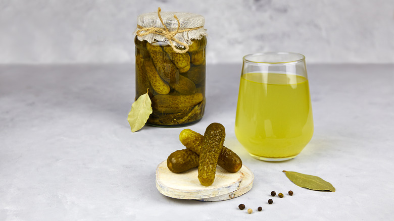 jar of pickles next to glass of pickle juice