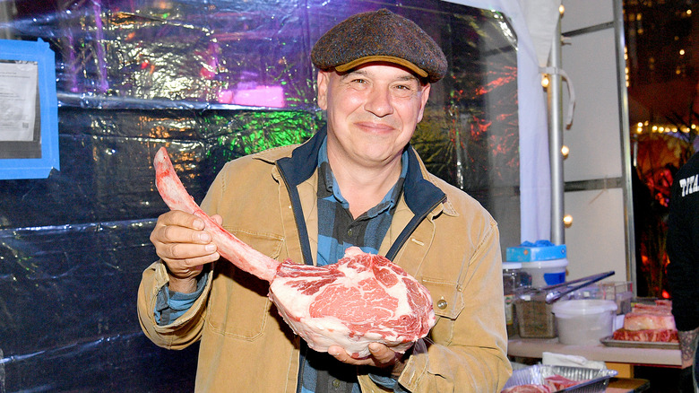 Chef Michael Symon holding giant meat