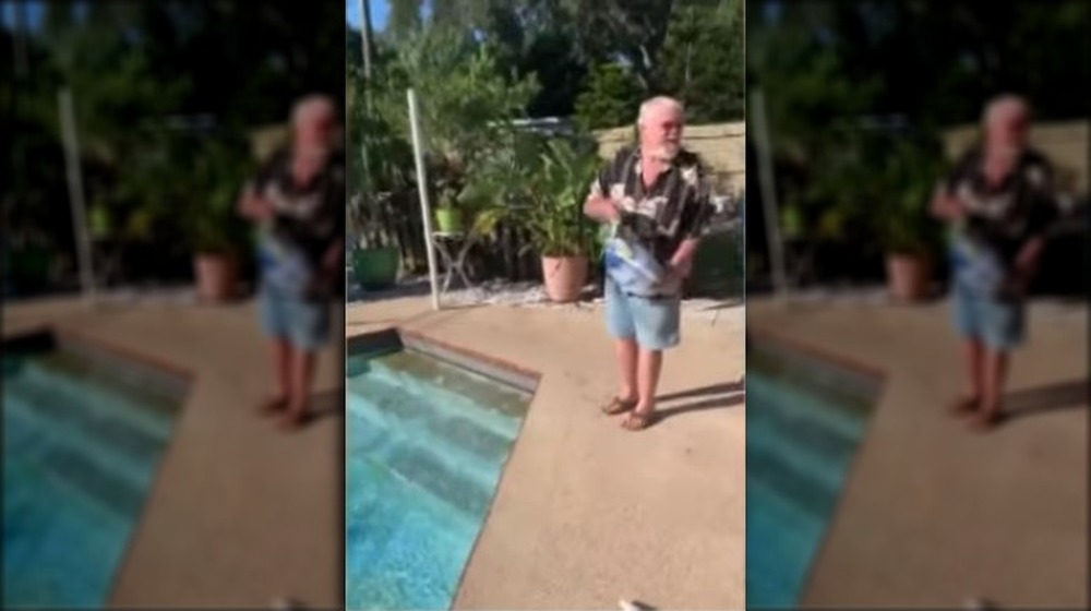 Man ready to throw a frozen turkey in a swimming pool