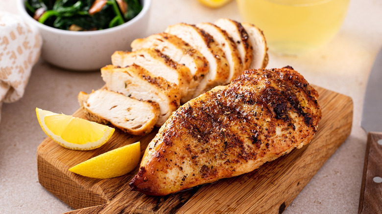 Sliced grilled chicken breast on cutting board