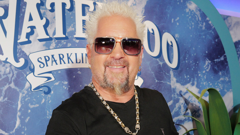 Guy Fieri in sunglasses smiling at event