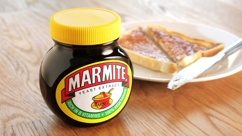 Jar of Marmite beside plate of Marmite toast