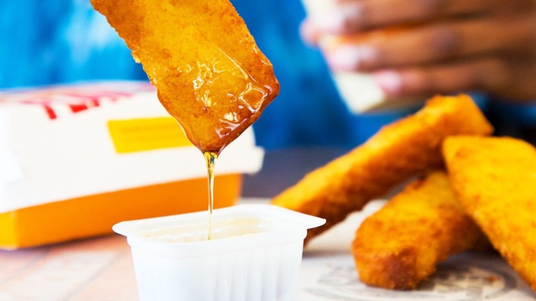 French toast sticks dipped in maple syrup