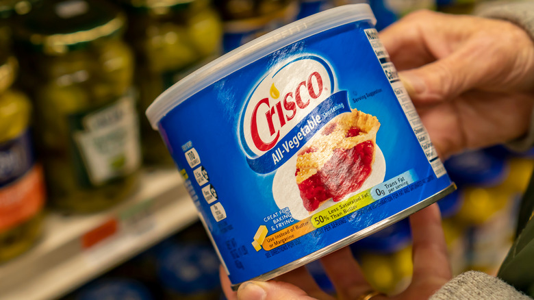 hands holding Crisco shortening