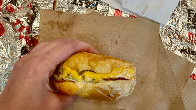 cheese burger in hand