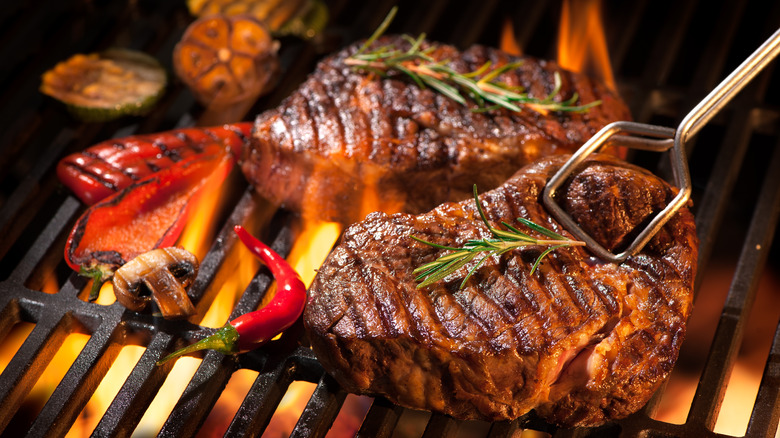 steak over flames on grill