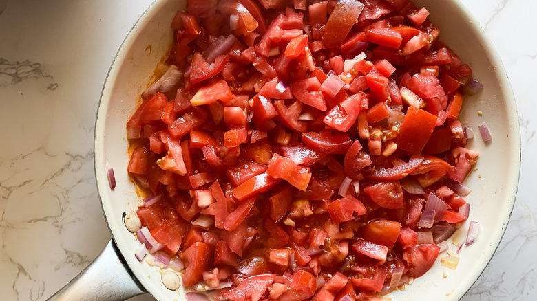 Sautéed tomatoes, onions, and garlic in a skillet