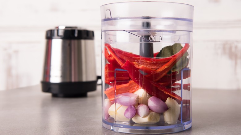 A food chopper filled with produce 