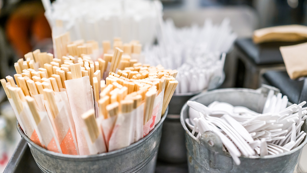 Tins of takeout utensils, with chopsticks in focus