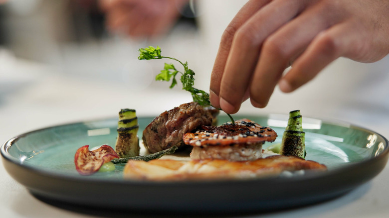 Chef placing garnish on dish