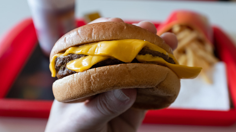 double cheese burger in hand