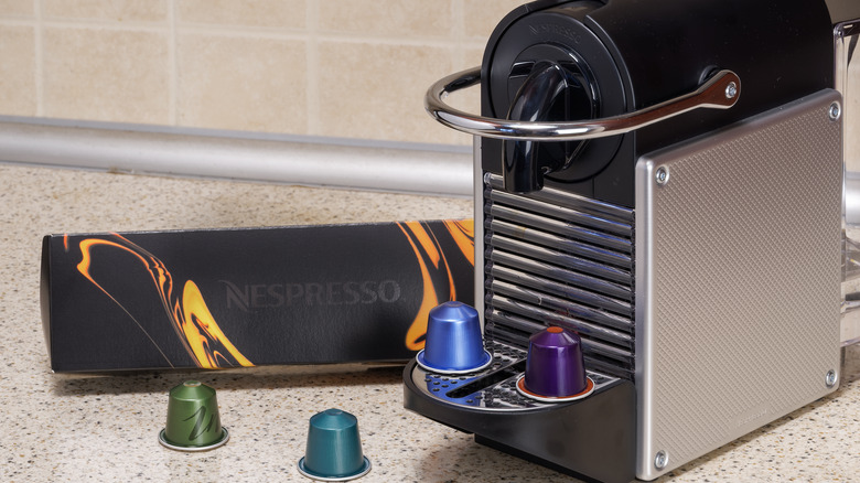 Nespresso machine next to pods