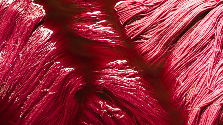 Silk threads soaking in red dye