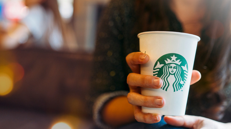 Woman holding Starbucks cup