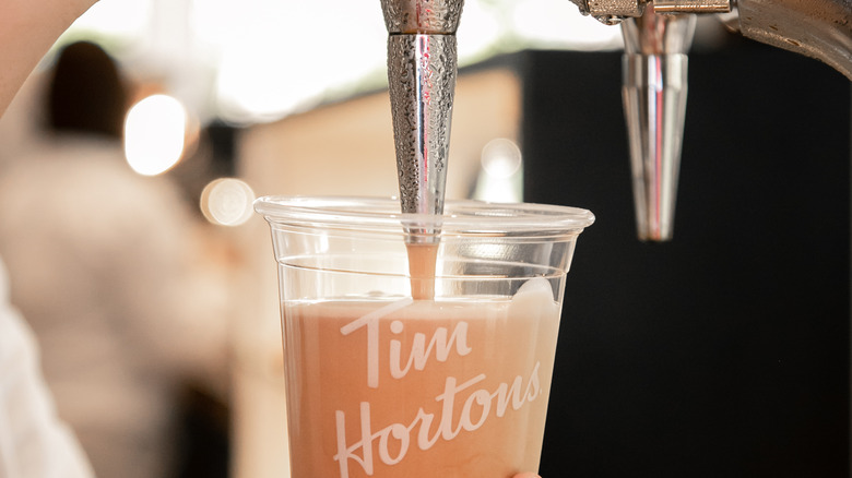 Tim Hortons employee making an iced coffee drink