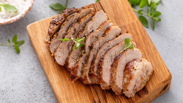 sliced pork tenderloin on cutting board