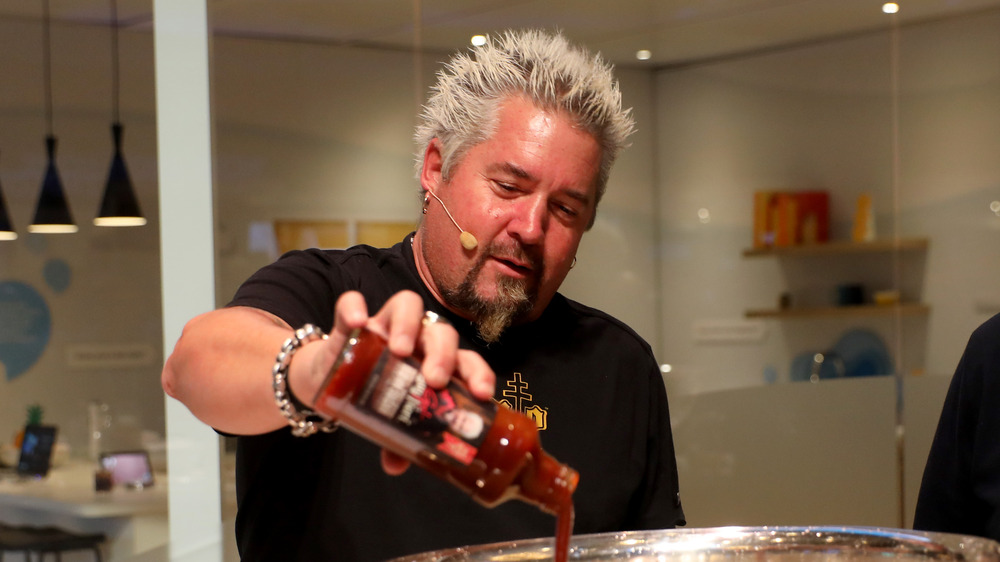 Guy Fieri with a bottle of sauce