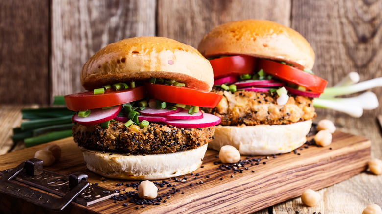 two gourmet homemade vegan burgers on wood cutting board